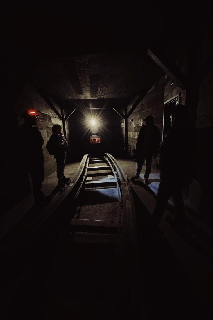 Crew silhouetted around a ride track in a dark set.