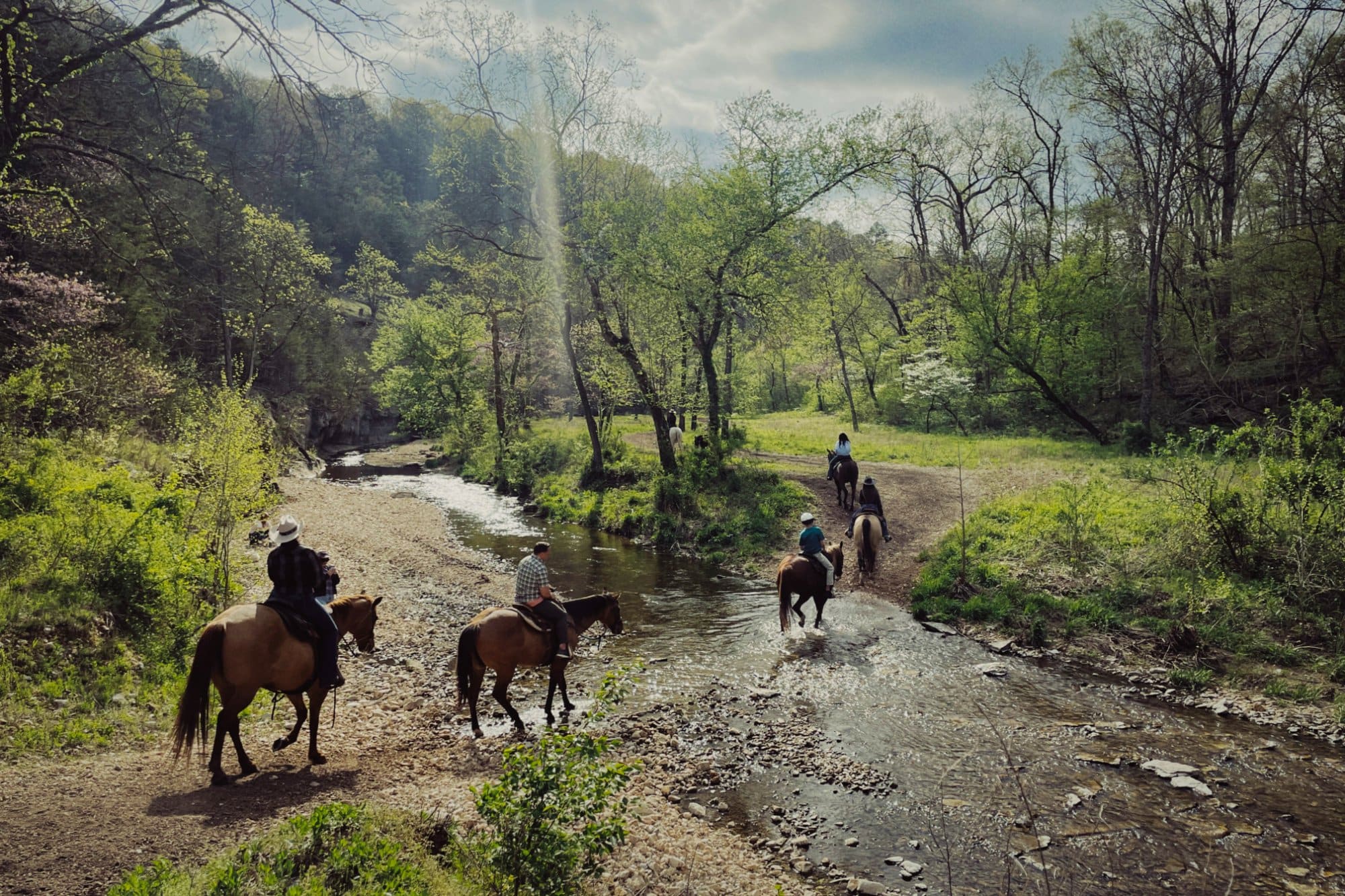 Horseback riders crossing a creek in the Ozarks