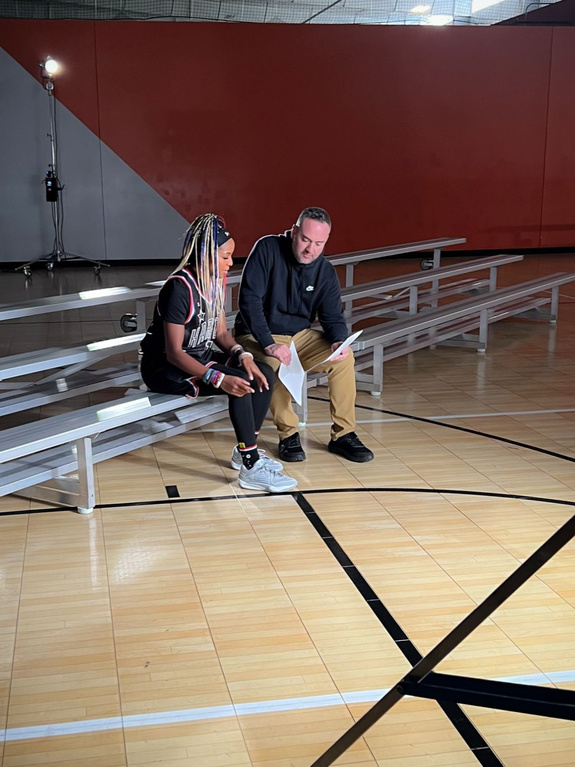 Globetrotters cast member going over notes with a director on the bleachers